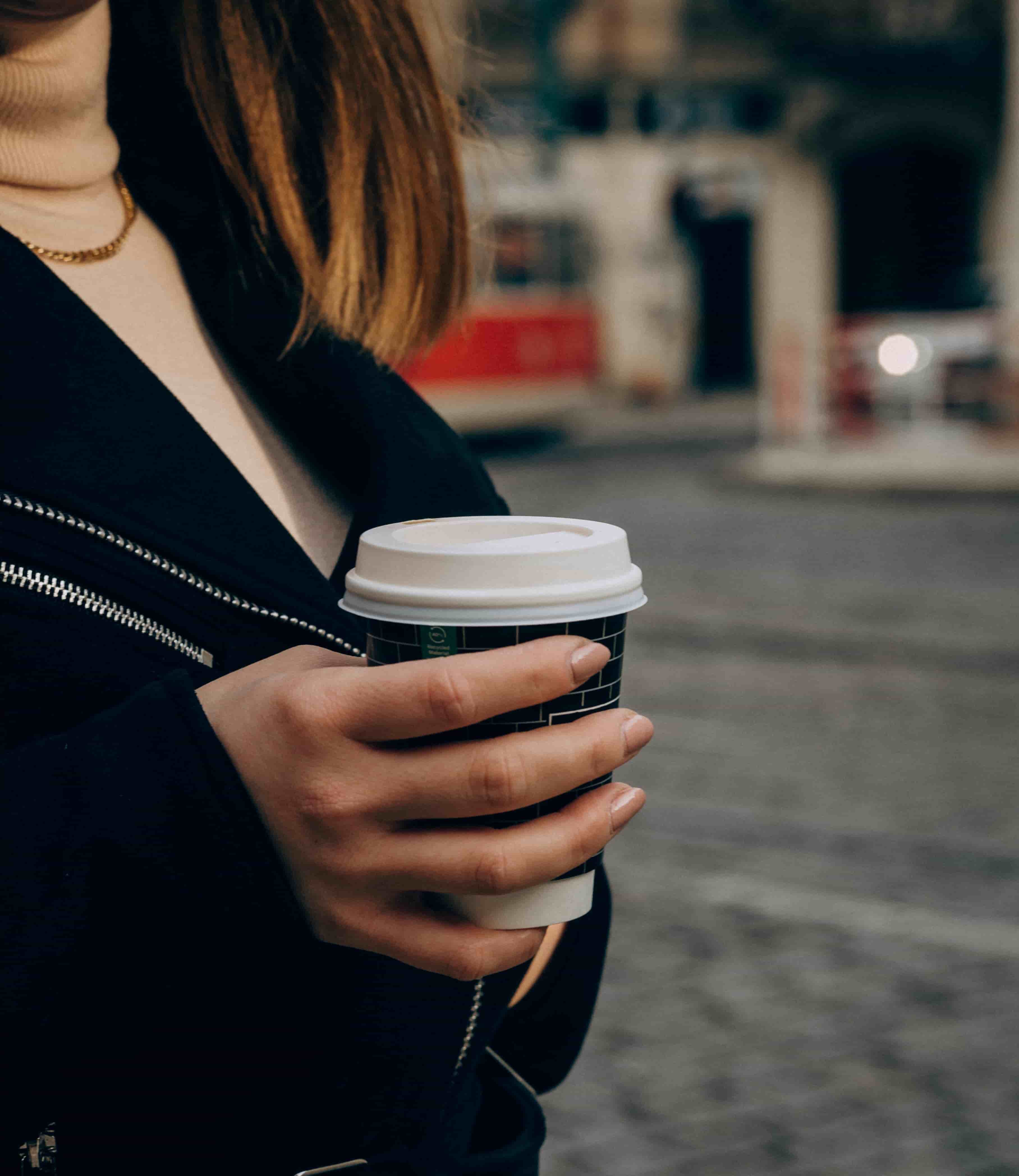 Image of person holding hot beverage